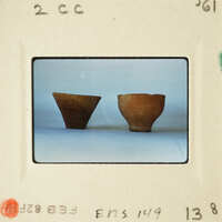 Two clay pots on a white surface.