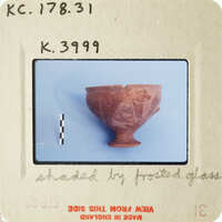 Broken clay pot with visible cracks and missing pieces, photographed on white background.