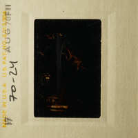 This is an image of a vintage film strip with a dark, blurry photograph of a person.