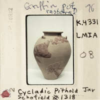 A photograph of a vase with handwritten notes and labels, including the word "Cycadic".