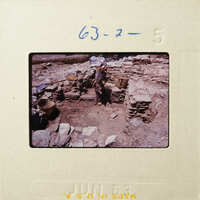 This is an old photograph showing ruins with stones and debris, possibly from an archaeological site.