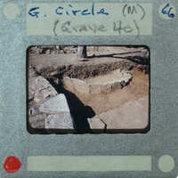 An old photo of a stone structure with handwritten notes on the border.