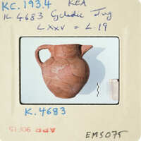 Ancient vase on display with visible damage and markings.