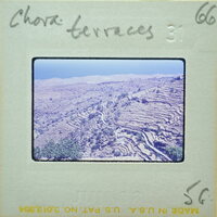 A vintage film strip with a photo of rugged terrain and mountains.