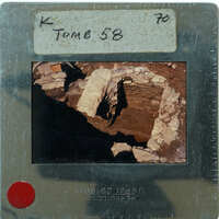 A photograph of an excavated archaeological site with stone ruins and a dirt floor, displayed on a film strip.