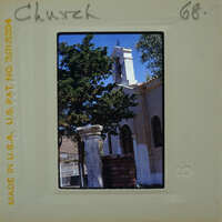 An old church with a bell tower and trees.