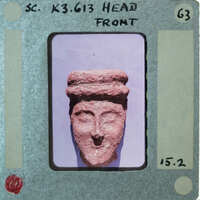 Terracotta face of figurine from front.