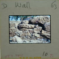 A photograph of a rock wall with a label on the bottom left corner.