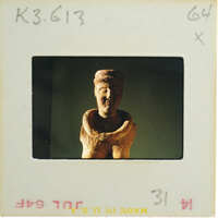 A photograph of an old, weathered clay sculpture with a humanoid form.