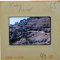 The image shows a vintage photograph of a mountainous landscape with terraced fields.