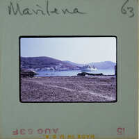 Picture of a beach with mountains and boats, labeled "MARLENA" on a film strip.