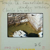 Detail of interior corner of tall stone wall with base under water.