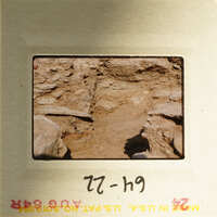 A photograph of a cave entrance with natural rock formations and sunlight filtering through.