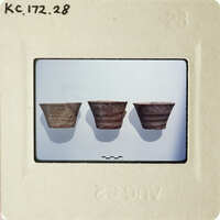 Three clay pots displayed on a white surface.