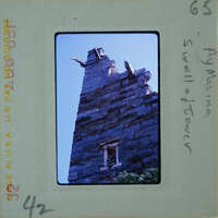 Old stone castle tower with a blue sky background.