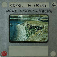 A vintage film strip showcasing a coastal landscape with a body of water and rocky terrain.