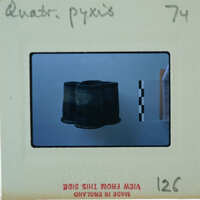 A vintage film strip with a single frame showing an object, possibly a hat or helmet.