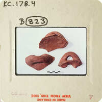 Old clay pottery fragments on white surface.