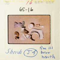 A collection of broken pottery pieces on a table, with some items placed atop others.