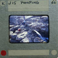 A film strip showing a person working on a rocky surface with water flowing nearby.
