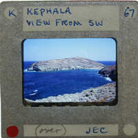 A vintage film strip with a label showing a view from SW Kepala, featuring an ocean and island landscape.