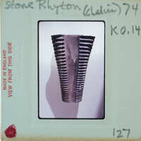 This is a photograph of an old, rusted metal object with ridges or teeth, possibly part of a machine or tool.