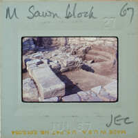 This is a vintage photo of an archaeological site with ruins and stones, possibly from ancient times.