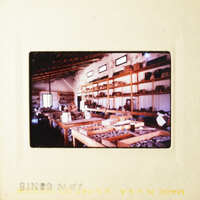 Photo: A vintage photograph of an interior space with shelves and items, possibly a shop or storage area.