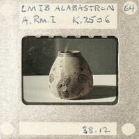 A small, ornate vase with a floral pattern on display.