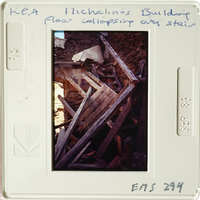 A photograph showing an interior with collapsed walls and debris, likely from a building collapse.