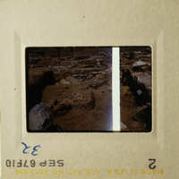 The image shows two 35mm film strips with scenes from an archaeological site, featuring ancient ruins and rock formations.