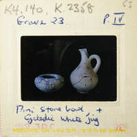 Old white jug with handle and spout on black background.