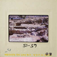 Ancient ruins with stone walls and dirt ground.