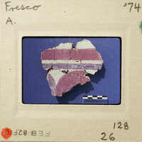 A photograph of an artifact, possibly pottery, with visible cracks and layers on a blue background.