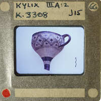 A photograph of an antique vase with intricate designs on a white background.