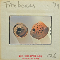 Two antique fireboxes on display with holes and textured surfaces.