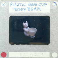 A small plastic bear figurine holding a cup of coffee on a film strip.