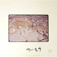 Ancient ruins with stone structures and dirt ground, photographed on film.