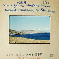 View from KEA, Greece: A serene beach scene with clear blue water and distant hills under a bright sky.