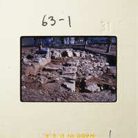 Old ruins with broken stones and dirt, possibly an archaeological site.