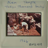 Man working on ancient ruins with stone structures and dirt.