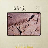 Old photograph showing rock formations with visible cracks and crevices.