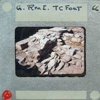 Old photo of a stone wall with handwritten text on the border.