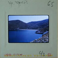 A photograph of a serene landscape with a body of water and mountains, displayed on an old film strip.