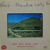 A slide showing a mountainous landscape with stone walls and green vegetation.