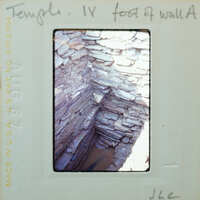 Interior corner of stone wall with water collecting on floor.