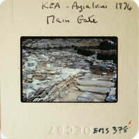 A photograph of an ancient archaeological site with stone ruins and vegetation.