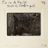 The image shows a vintage photograph of an underground cave or mine with rock formations and debris, enclosed within a film strip border.