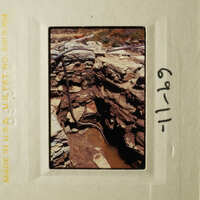 This is an image of a rocky, excavated area with exposed layers and piping, possibly a construction site or geological feature.