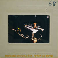 This is a photo of an old-fashioned kitchen with a table and various items on it, including what appears to be a dog.